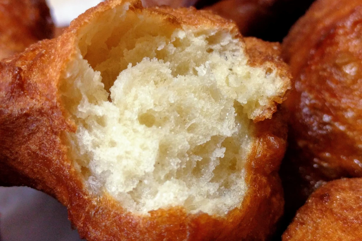 Freshly fried Moroccan Sfenj doughnuts strung on a palm frond ribbon
